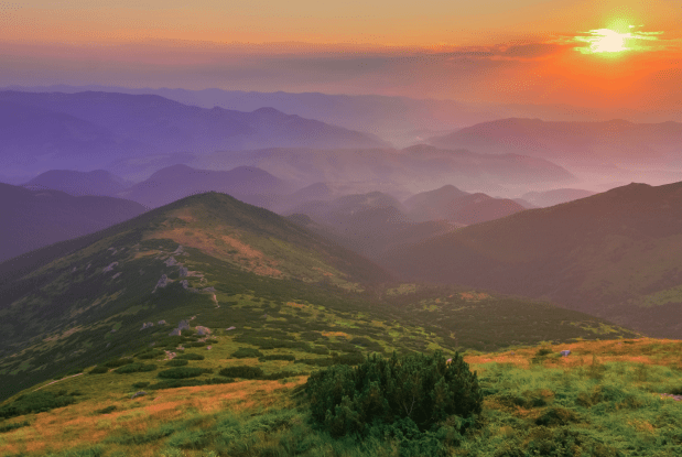 Sunset over serene mountain landscape, symbolizing peace and support through survivor assistance and bereavement financial advice.