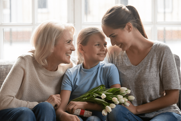 Three generations of women sitting together with flowers, representing family legacy and estate planning services.